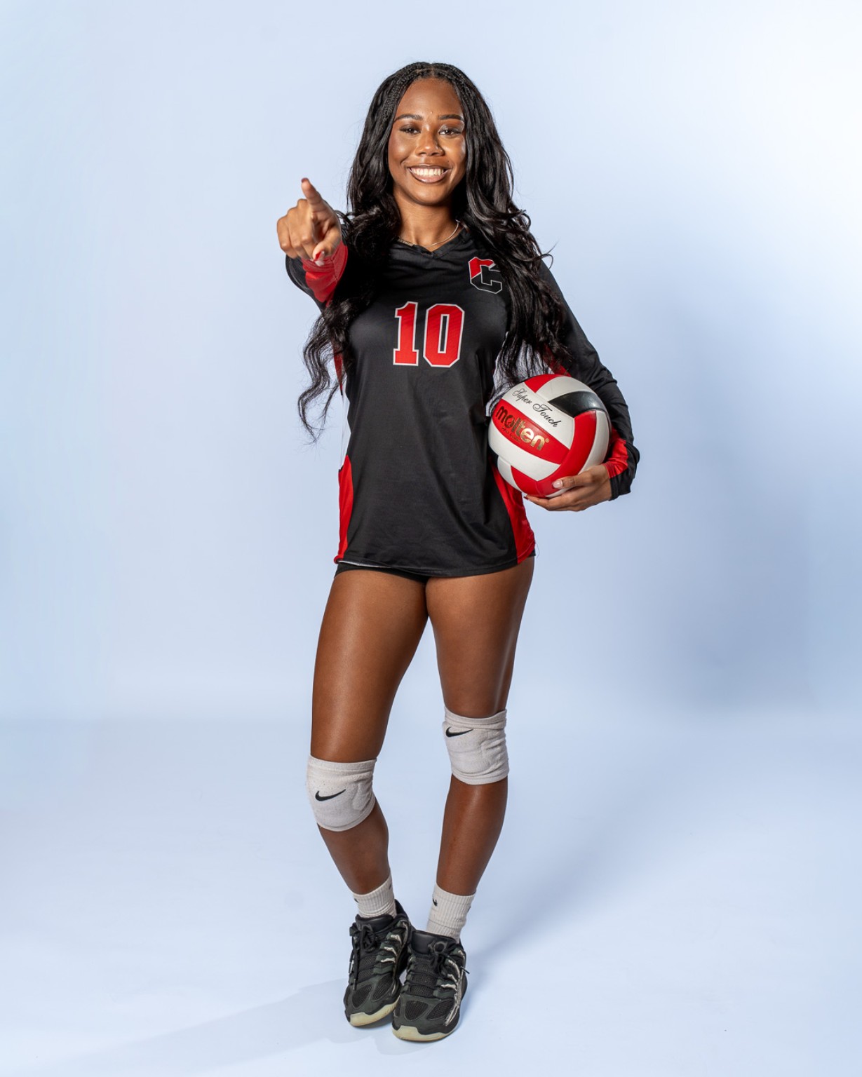 Cinnaminson Pirates volleyball player holding a volleyball in a studio portrait